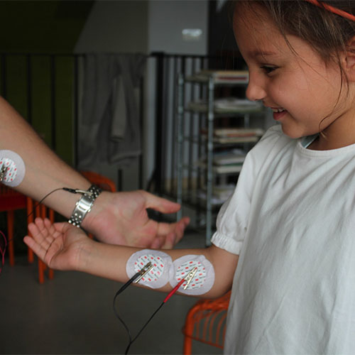 Dete i nastavnik eksperimentisu sa elektrodama