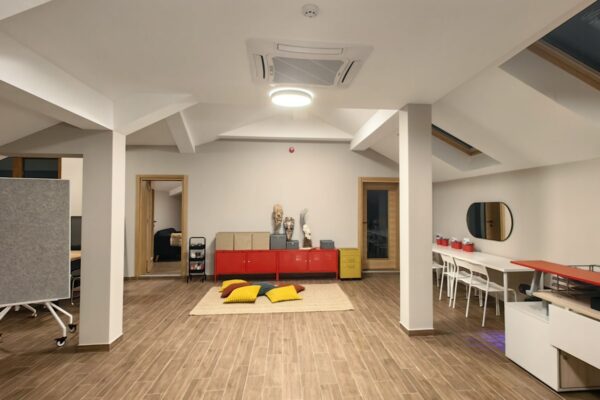 Prostor za ucenje sa crvenim ormaricima i zutim i crvenimi jastucima na podu u Pravac skoli