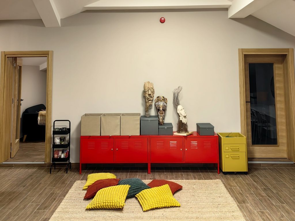 Prostor za ucenje sa crvenim ormaricoma i zutim i crvenimi jastucima na podu u Pravac skoli