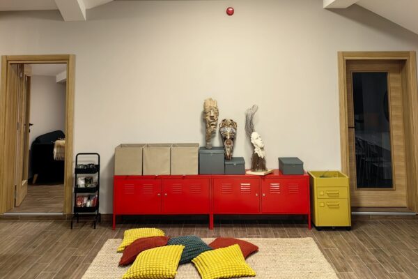 Prostor za ucenje sa crvenim ormaricima i zutim i crvenimi jastucima na podu u Pravac skoli